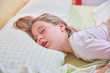 © Q - funny expression face with open mouth of blonde caucasian five years old girl,  sleeping on king bed