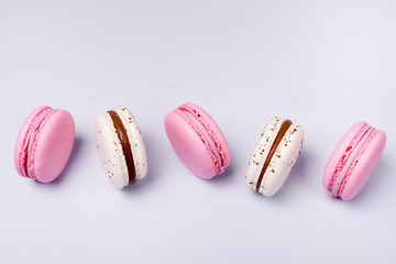 Wall Mural - Pink Strawberry and White Caramel and Salt Macarons French Delicate Dessert Pink and White Pastel Macarons on Blue Background