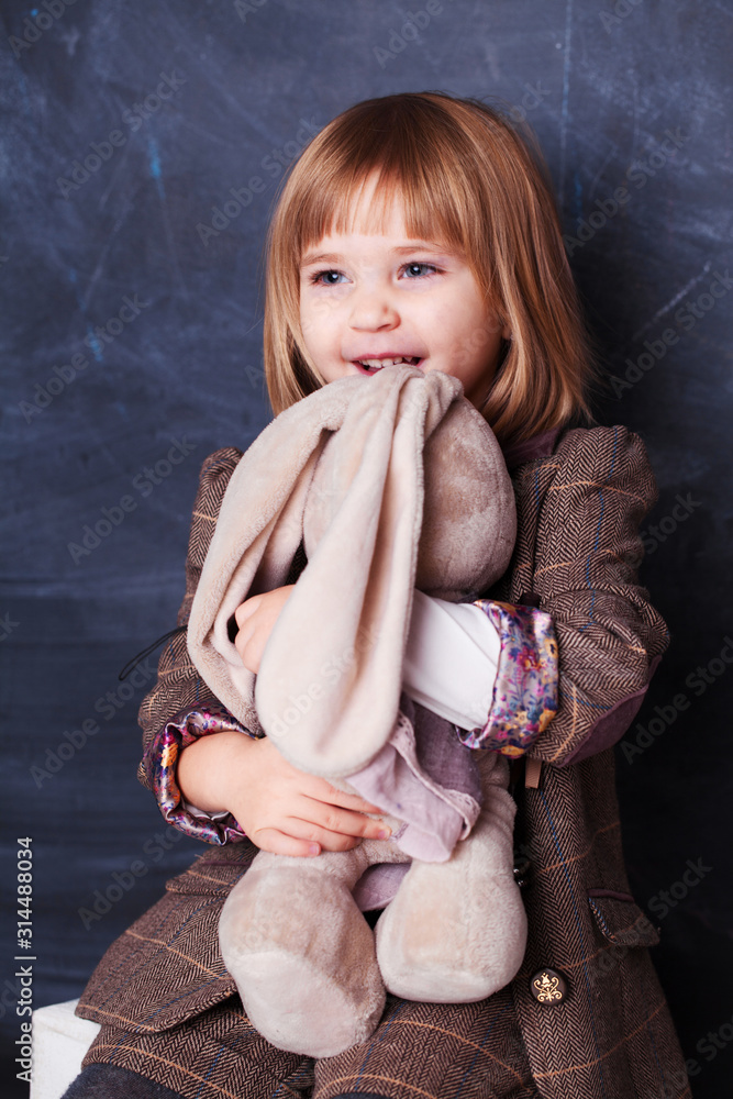 Cute Happy little girl hugging her toy rabbit Stock Photo | Adobe Stock