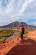 © Bisual Photo - Photographer taking pictures of red earth formations in Quebrada de las Conchas, Salta Region, Argentina