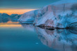 Water reflecting arctic sunset and icebergs