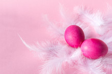 2 Pink Easter Eggs On White Feathers On A Pink Background
