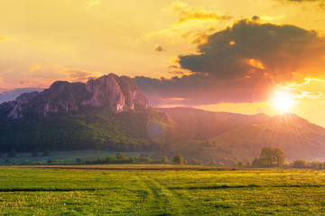 Wall Mural - rock formation on the field at sunset. beautiful rural landscape in mountains. wonderful scenery in 