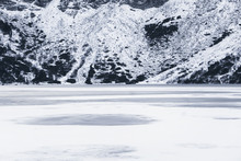 Frozen Lake In Tatra Mountains. Against The Backdrop Of Snow-capped Mountains