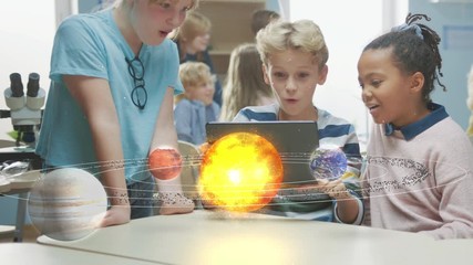 Wall Mural - three diverse school children in science class use digital tablet computer with augmented reality so