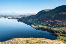 Beautiful Autumn Fall Landscape Of Ullswater And Surrounding Mountains And Hills Viewed From Hallin Fell On A Crisp Cold Morning With Majestic Sunlgiht On The Hillsides