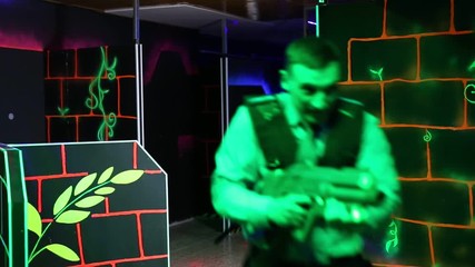 Wall Mural - Men and women in business suits playing laser tag emotionally in dark room