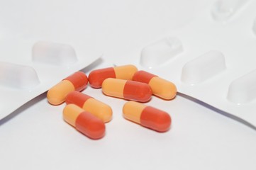 Wall Mural - Red and orange capsules isolated on white background