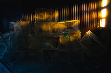 Artistic Lighting In The Warehouse Of Fishing Nets And Gear. The Pronounced Rays Of The Sun From The Window On The Wall.