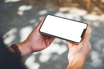 Mockup image of hands holding black mobile phone with blank desktop screen