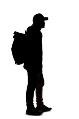 silhouette of a man hiking and carrying a backpack on a white background. the isolated side view man