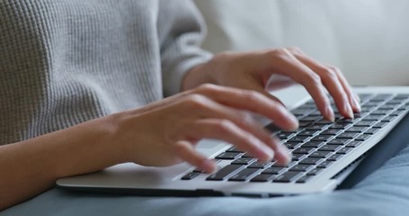 Woman type on notebook computer at home