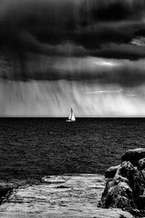 Canvas Print - Greyscale of a sailing ship on the sea under a dark cloudy sky during daytime