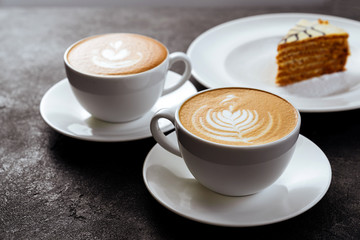 two cups of coffee on black stone background Top view