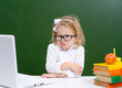 © Ermolaeva Olga - Cute little girl in glasses is working on a laptop at school and showing displeased funny faces