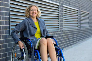 Wall Mural - young adult woman on wheelchair on the street