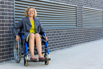 Wall Mural - young adult woman on wheelchair on the street