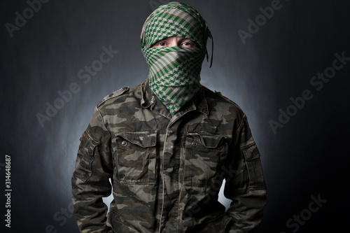 Cuadros en Lienzo Terrorist in military uniform and mask on dark background
