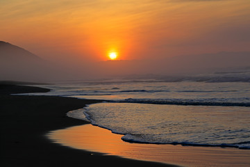 Poster - Seascape at sunrise with and warm colors and reflections from the early morning sun, South Africa.