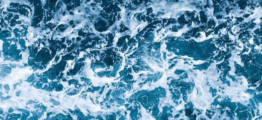 Aerial view of salt ocean waves. Blue water aqua sea background ot texture. Rippled spashing waves wide banner panoramatic photo.