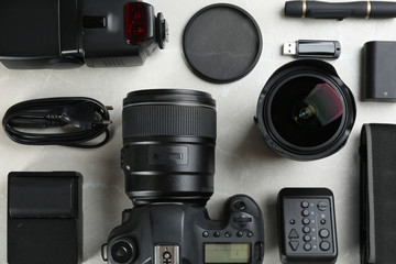 Flat lay composition with equipment for professional photographer on grey marble table