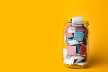 Glass Jar Full Of Folded Paper Sheets On Yellow Background, Space For Text
