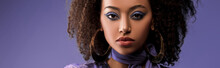 Panoramic Shot Of Attractive African American Woman With Earrings Looking At Camera Isolated On Purple