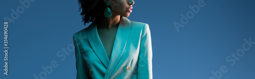 Fotografía panoramic shot of african american woman in suit isolated on blue