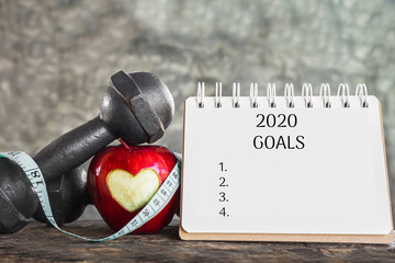 Wall Mural - 2020 goals for sport concept with red apple,dumbbell and resolution list on calendar 