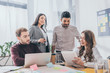 © LIGHTFIELD STUDIOS - selective focus of cheerful multicultural businessmen and businesswomen with gadgets