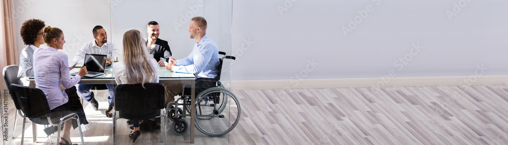 Disabled Manager Sitting With His Colleagues - obrazy, fototapety, plakaty 