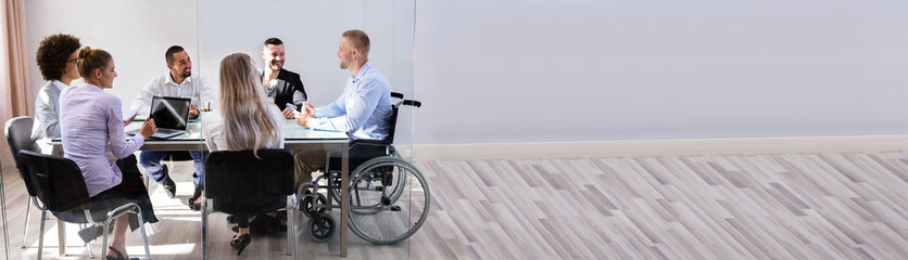 Disabled Manager Sitting With His Colleagues