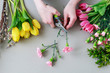 canvas print picture - Woman shows how to make beautiful floral arrangement with tulip and carnation flowers