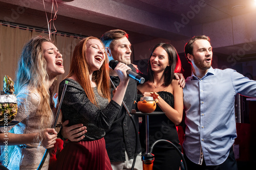 Cuadros en Lienzo young ladies and guys chilling and rocking in karaoke bar, spend day-off in kara