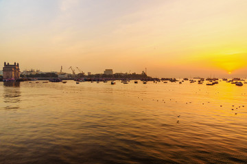 Wall Mural - Gateway of India and fisherman boats in water of Arabian Sea on sunrise. Mumbai. India