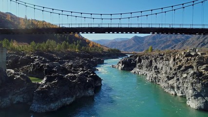 Wall Mural - Suspension bridge over a mountain river. Katun, Altai Mountains, Russia.