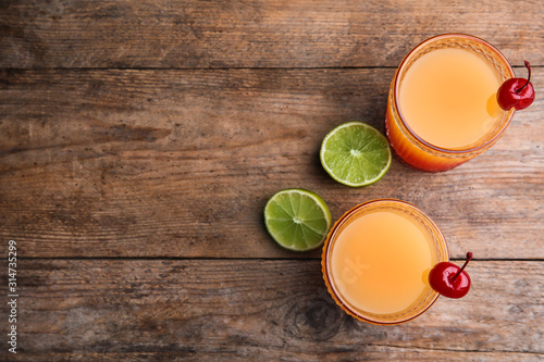 Fotografía Fresh alcoholic Tequila Sunrise cocktails on wooden table, flat lay