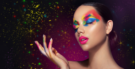 beautiful girl with festive bright multi-colored make up on the face. young woman dressed in extrava