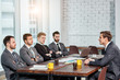 © alfa27 - young caucasian manager or boss in tux talk with co-workers, business coworking of stylish elegant men gathered together, have successful interaction in modern executive boardroom