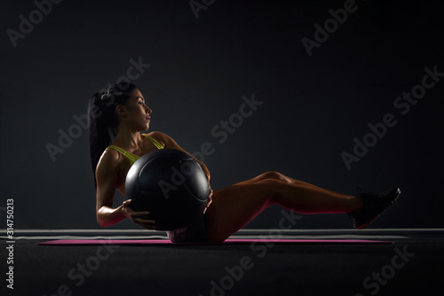 Fotomural Sportswoman training abs with ball in gym.
