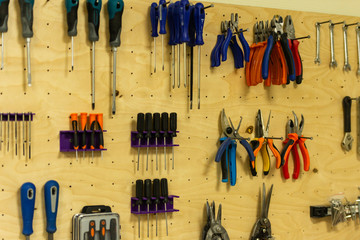 Shelf with tools. The hand tools are hung in their places. Organization of the working space in the workshop.