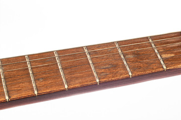 fretboard of an old yellow red wooden guitar with strings close-up isolated on a white background