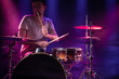 © puhimec - The drummer plays the drums. Beautiful blue and red background, with rays of light. Beautiful special effects smoke and lighting. The process of playing a musical instrument. Close-up photo.