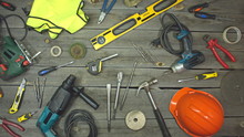 A Variety Of Electro And Hand Tools And Special Clothing. Top View.  On The Table Are Tools For Various Types Of Construction And Repair Work On Wood, Metal, Concrete, Plastic And Other Materials.