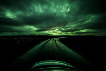 Wall Mural - Aurora Borealis (Northern Lights) above a wet road landscape