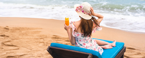 Young asia woman relax on beach with cocktail.