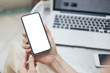 © panitan - Mockup image blank white screen cell phone.man hand holding texting using mobile on desk at office.background empty space for advertise text.people contact marketing business,technology