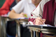 © panitan - high school,university student study.hands holding pencil writing paper answer sheet.sitting lecture chair taking final exam attending in examination classroom.concept scholarship for education abroad