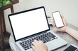 © panitan - mockup image blank screen computer,cell phone with white background for advertising text,hand man using laptop texting mobile contact business search information on desk in cafe.marketing,design