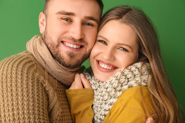 Wall Mural - Portrait of happy couple in winter clothes on color background